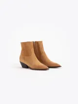 Bota de caña baja confeccionada en cuero descarne color marrón, con diseño de punta fina y tacón bajo de madera.