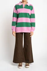 Sweater tipo polo de manga larga con diseño de rayas horizontales anchas en color rosa y gris. Presenta cuello camisero con cierre frontal de botones y puños elásticos.