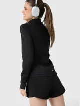 Campera deportiva negra de manga larga con cuello alto, cierre frontal completo y bolsillos laterales con cierre. Presenta detalles de costuras anatómicas y puños con abertura para el pulgar.
