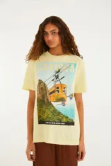 Remera de manga corta color amarillo, de calce relajado, con cuello redondo y estampa frontal alusiva a Río de Janeiro.