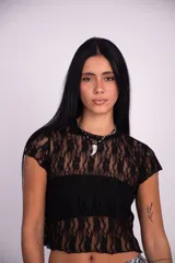 Top de encaje negro con mangas cortas y diseño traslúcido, de corte corto y ajuste al cuerpo.