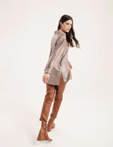 Camisa oversized con terminación metalizada color gris plomo. Tiene botones a tono en el delantero, largo por debajo de la cadera y tajos a los costados.