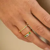 Anillo de plata 925 bañada en oro 18k con una piedra central de topacio azul rectangular y una esmeralda circular a cada lado.