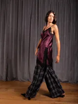 Top asimétrico de raso color bordó con escote en V y detalles de encaje negro en el escote y el dobladillo.