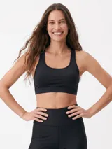 Top deportivo negro con diseño de espalda deportiva y escote redondo.