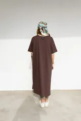 Vestido largo marrón con cuello redondo y mangas cortas con ribete amarillo. Estampado frontal con letras en color crema.