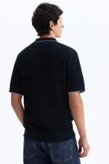 Remera polo azul marino en punto texturizado de mezcla de algodón, con cuello y bordes de mangas acanalados con ribete blanco, tapeta con tres botones y manga corta.