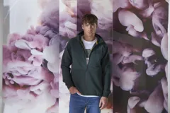 Campera verde oscuro con capucha, cierre frontal y bolsillos laterales.