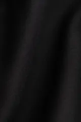 Top negro de tejido suave con efecto neopreno, escote en V, hombros caídos y mangas largas con puños ceñidos. Presenta una cintura entallada que realza la figura.