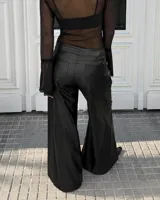 Pantalón negro de cuero sintético, de corte amplio y silueta recta con botamanga ancha.