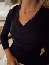Camiseta negra de algodón con escote en V y detalle de encaje en el borde.