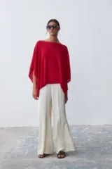 Poncho tejido de punto color rojo con cuello bote y corte asimétrico.