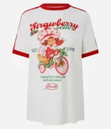 Remera blanca de algodón con mangas cortas, cuello redondo y ribetes rojos en contraste. Presenta estampa frontal de Strawberry Shortcake y lettering con texto en inglés y rojo.