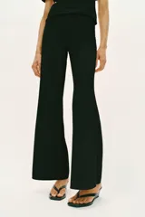 Pantalón largo negro de tiro alto, confeccionado en tejido elástico, con cintura elástica y diseño de pierna ancha tipo palazzo con bajo evasé.