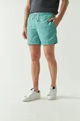 Short de baño liso con cintura elástica y cordón ajustable. Cuenta con dos bolsillos laterales, un bolsillo trasero y logo bordado. Confeccionado en tela ligera de secado rápido.