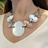 Collar corto con cordón gris, piezas ovaladas de resina blanca y transparente unidas por eslabones dorados.