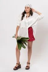 Camisa amplia blanca con bolsillos frontales gigantes y cierre frontal con botones.