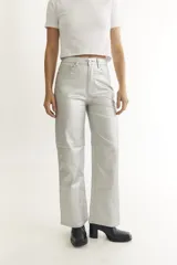 Pantalón plateado de cuerina, corte recto y cinco bolsillos funcionales.