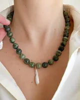 Collar de piedras esféricas color verde jaspeado, con un dije colgante de perla natural en forma de lágrima y cierre metálico dorado.