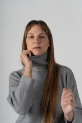 Sweater gris de tejido de punto, con cuello alto y mangas largas.