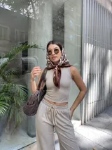 Top musculosa beige de tela Morley Fine Lines elastizada, con textura rib bicolor y detalle de tachas en el vivo de la manga.