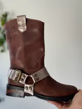 Bota de cuero marrón con estribo desmontable plateado.