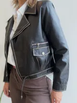 Campera tipo biker de ecocuero color chocolate con detalles de costuras en contraste color beige claro. Presenta cierre frontal metálico, bolsillos laterales con cierre y puños con cierre y botón a presión.