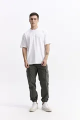 Remera de manga corta color verde militar, con escote redondo y fit regular. Presenta un pequeño estampado de texto en el pecho.