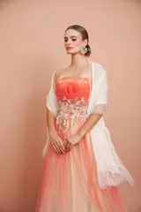 Vestido largo strapless de tul en degradé con tono coral y crema, con telas superpuestas y detalles bordados en el talle.
