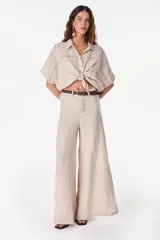 Pantalón de lino italiano con diseño estampado a rayas verticales en tonos negro y beige, de tiro medio y corte ancho.