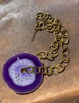 Collar de cadena de eslabones plateados con un dije central de piedra ágata natural en tono fucsia intenso con centro geoda.