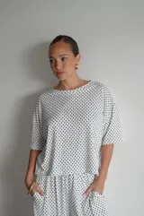 Pantalón negro de algodón y viscosa, con estampado de lunares blancos y corte holgado.