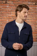 Overshirt de lana melange en color gris, con cuello camisero, cierre frontal de botones y dos bolsillos frontales con solapa.