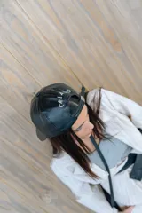 Gorra tipo béisbol de cuero sintético negro, con diseño minimalista y ajuste posterior metálico.