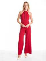 Enterito largo de crepe color rojo, con escote halter entrelazado, sin mangas y corte recto en las piernas. Cuenta con bolsillos delanteros, forro interno y cierre invisible en la espalda.