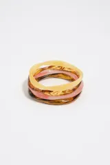 Pack de tres pulseras rígidas de resina en tonos tostado, marrón carey y rosado translúcido, con diseño de formas orgánicas.