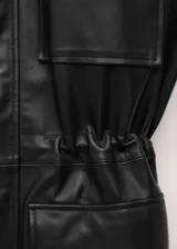 Parka oversize de piel ovino en color negro, con cuello de solapa, manga larga, bolsillos delanteros con solapa y cintura ajustable.