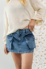 Minifalda de jean azul con bolsillos cargo frontales.