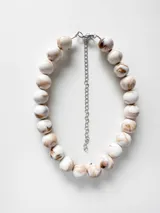 Collar de cuentas redondas con efecto marmolado en tonos blancos y marrones, con cadena de extensión metálica.