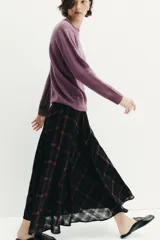 Falda midi de tiro alto con diseño acampanado y estampado de cuadros en tonos negro y marrón. Cuenta con cierre lateral oculto.