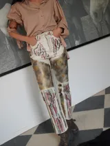 Pantalón de cuero color negro con estampado artístico en fucsia y blanco.