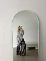 Conjunto compuesto por buzo gris asimétrico de manga larga y pantalón ancho de cuadros en tonos marrón, blanco y azul.