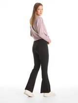 Legging de tiro alto con cintura ancha modeladora y faja interna de compresión. Presenta un diseño de pierna entallada con terminación acampanada en el bajo.