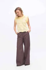 Pantalón de pierna amplia y tiro alto, confeccionado en tejido a rayas con una mezcla de algodón, poliéster y lino. Presenta un diseño de corte sastrero con bolsillos laterales y trabillas para cinturón.