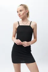 Vestido corto negro, ajustado al cuerpo, sin mangas y con escote cuadrado. La tela presenta una textura tramada o con relieve.