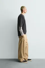 Sudadera de manga corta con corte relajado, confeccionada en algodón con interior de rizo. Presenta cuello redondo con detalle de costura en V, efecto lavado y estampado gráfico en el frente.