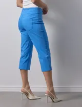 Pantalón capri blanco de gabardina elastizada. Pretina ancha elastizada, delantera con bolsillos simulados y trasera con bolsillos aplicados.
