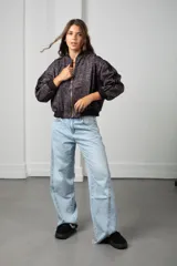 Campera bomber de gamuza con estampado animal print en tonos marrones. Presenta cierre frontal dorado, puños y cintura de tejido elástico negro, y bandas laterales negras en las mangas.
