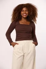 Blusa de manga larga color negro, con escote cuadrado y diseño ajustado con frunces laterales.