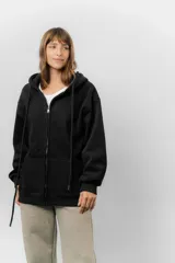 Campera deportiva con capucha de corte oversize, confeccionada en tejido suave con interior forrado en piel sintética. Presenta cierre frontal completo, bolsillos laterales y capucha amplia con cordones largos ajustables.